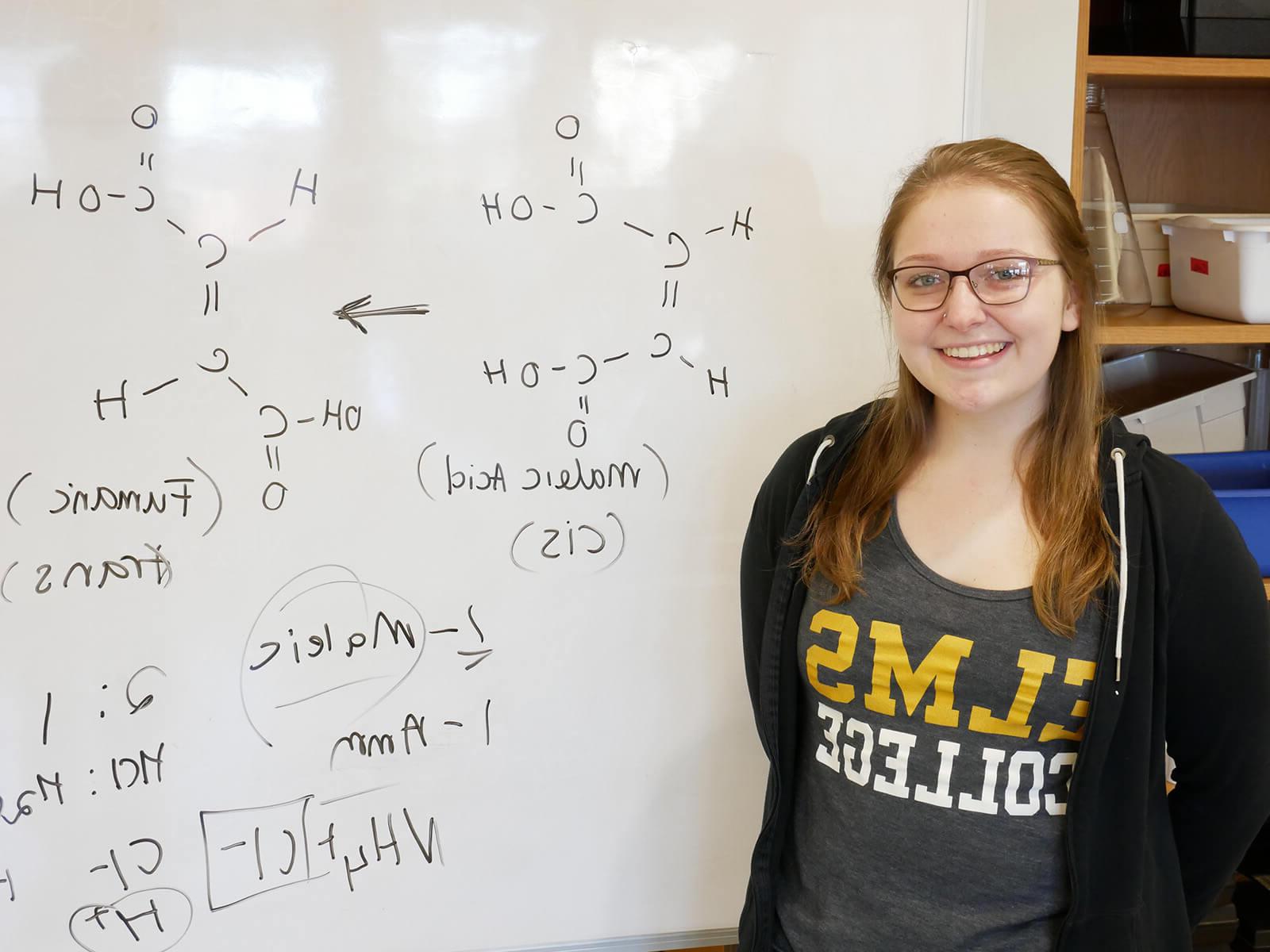 ElmSTEM博菜网站大全和化学专业的April Thresher在白板前的照片.